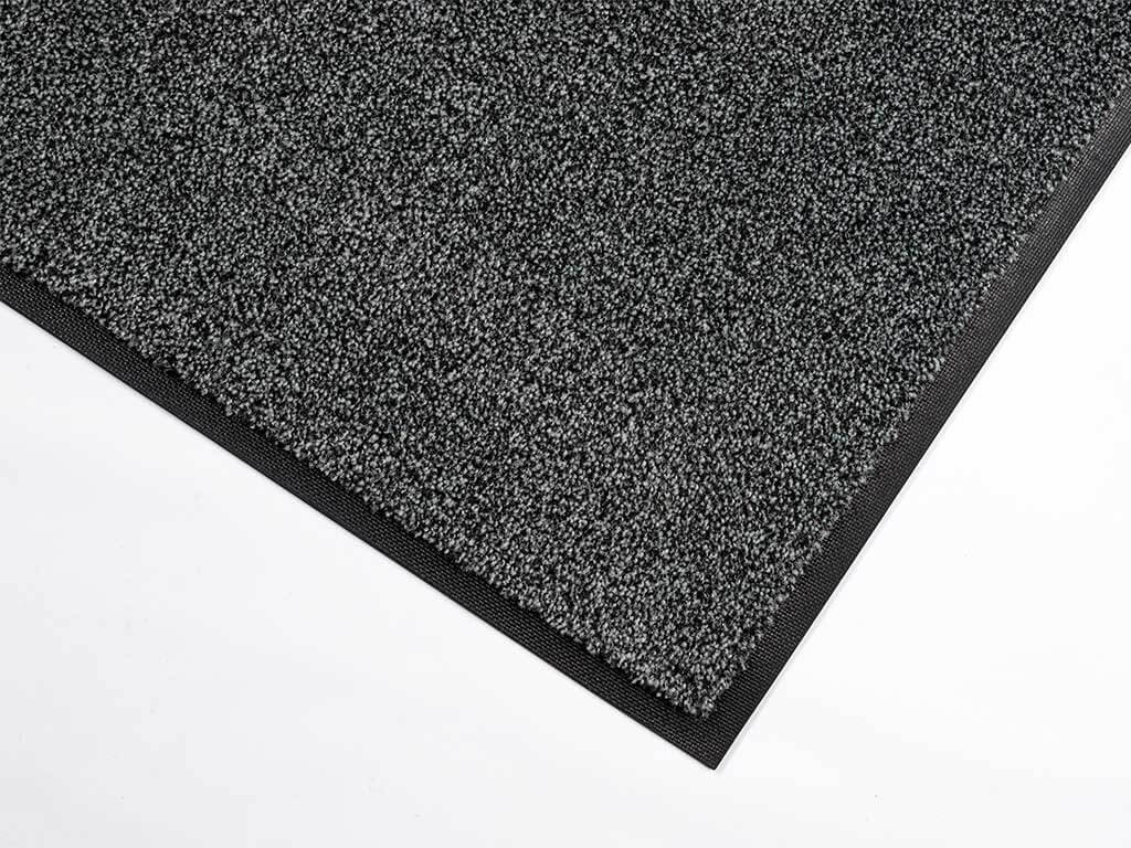 De rechtopstaande nylon vezels doen zand en stof verdwijnen in de mat De rechtopstaande nylon vezels doen zand en stof verdwijnen in de mat